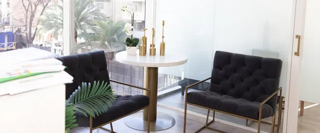 Sala de estar con sillones negros y mesa redonda